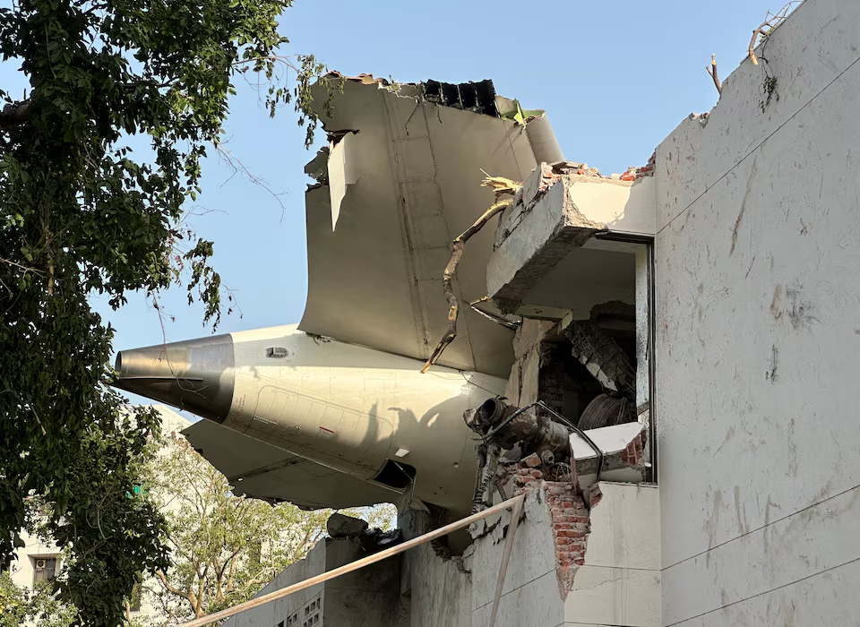 A tail of an Air India Boeing 787 Dreamliner plane that crashed is seen stuck on a building after the Ahmedabad plane crash, India